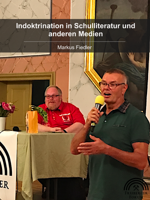 Referent Markus Fiedler am Rednerpult und Moderator mit Mikrofon im Vordergrund
